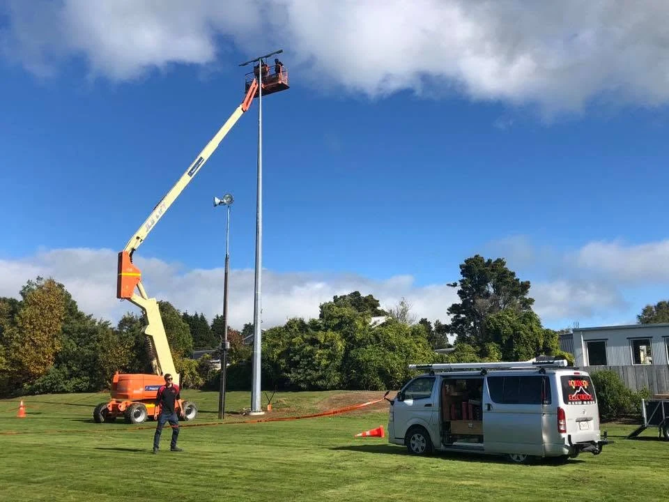 Robinson Electrical crew installing sports field lighting using an elevated work platform