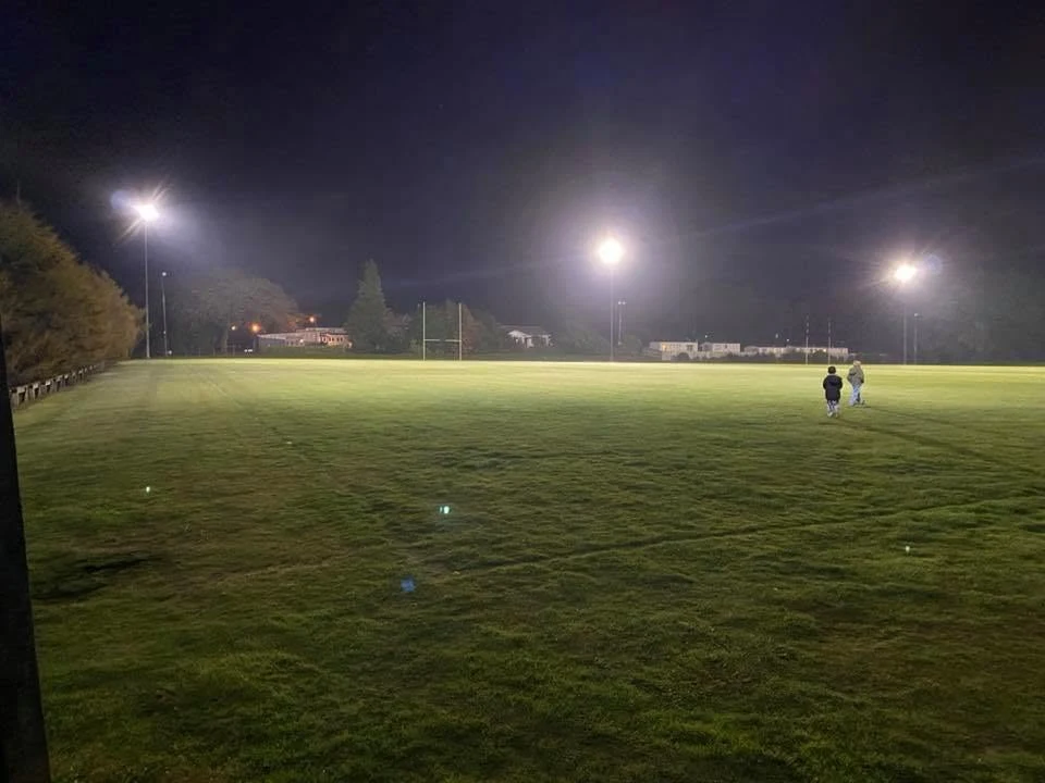Sports field illuminated by floodlights at night